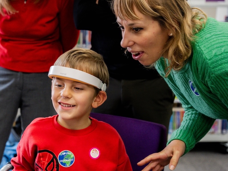 child wearing consumer brain scanner with mother alongside.